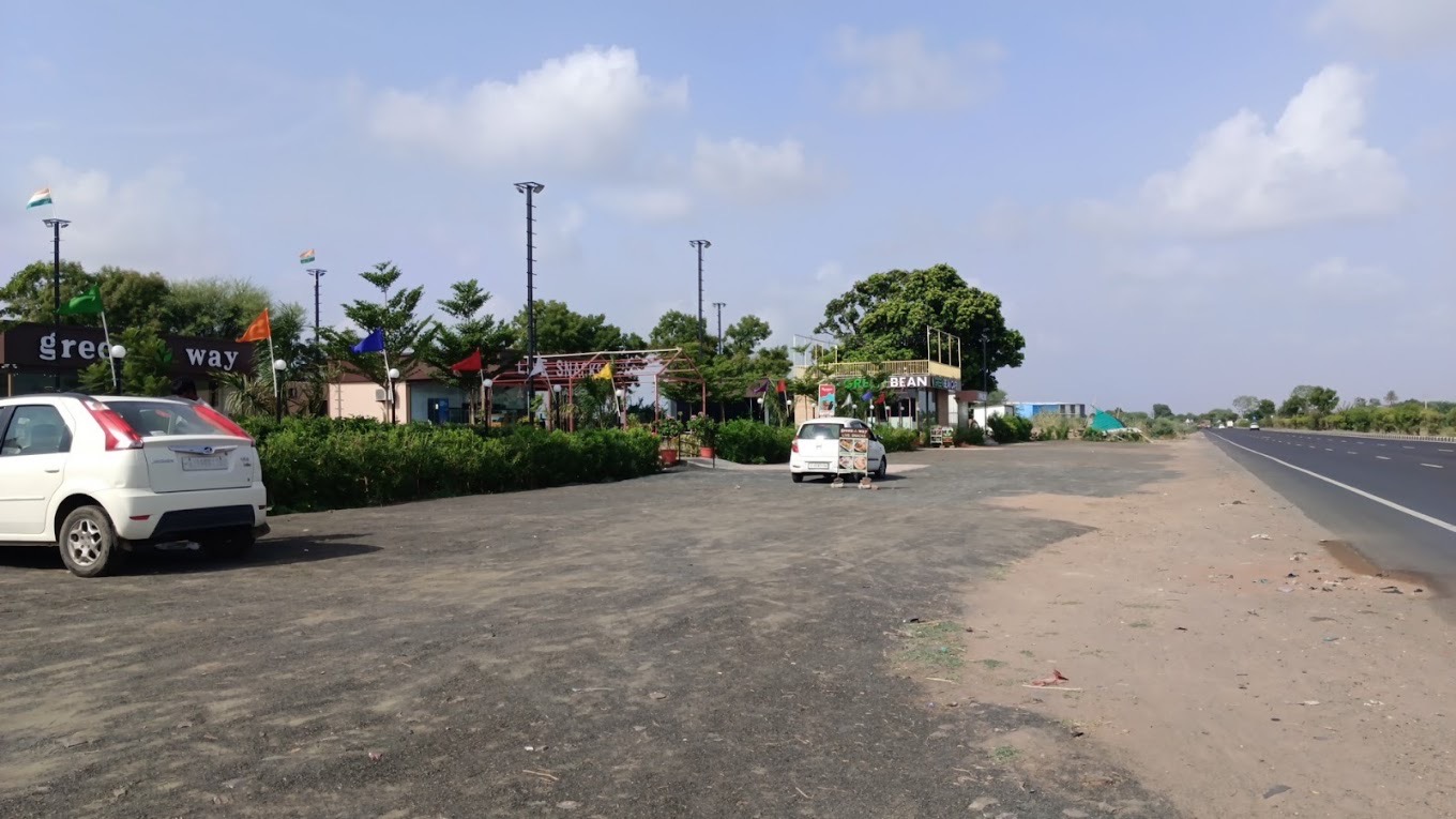 Greenway seen from NH 48: flags, the green way sign and parking in front